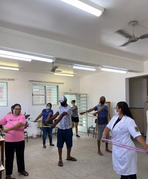 Lídia Catarina conduzindo exercícios em grupo com arcos