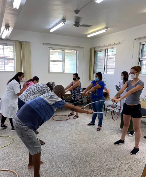 Grupo de idosos fazendo alongamento com arcos